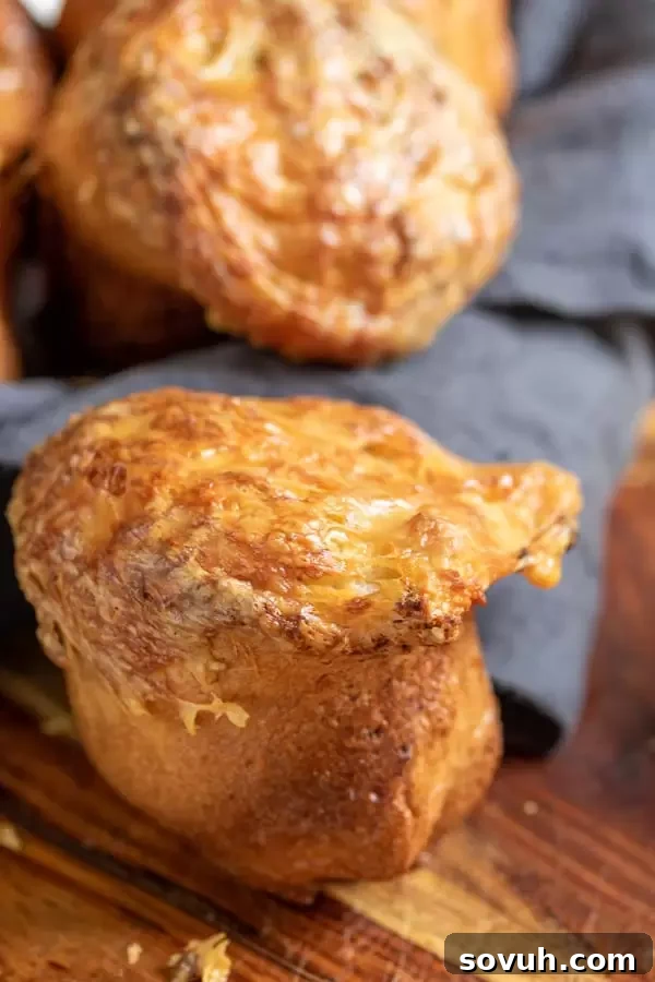 A basket full of golden-brown Gruyere Popovers, ready to be served and enjoyed as a delicious bread side.