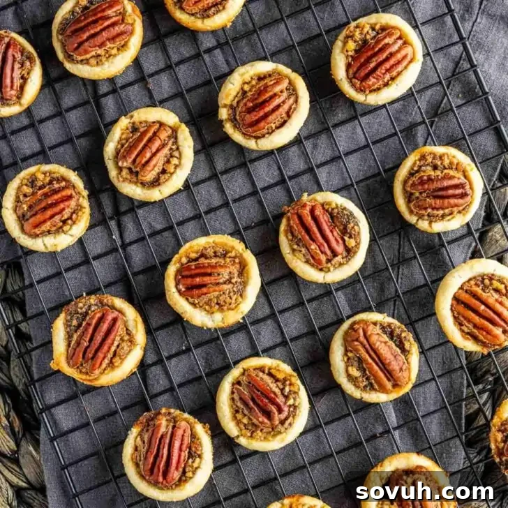 Mini pecan pies on a cooling rack.