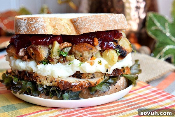 Layers of roasted turkey, creamy mashed potatoes, herb-infused stuffing, and sweet cranberry sauce combine to form a mouthwatering Thanksgiving Leftovers Sandwich, a perfect way to enjoy holiday favorites.
