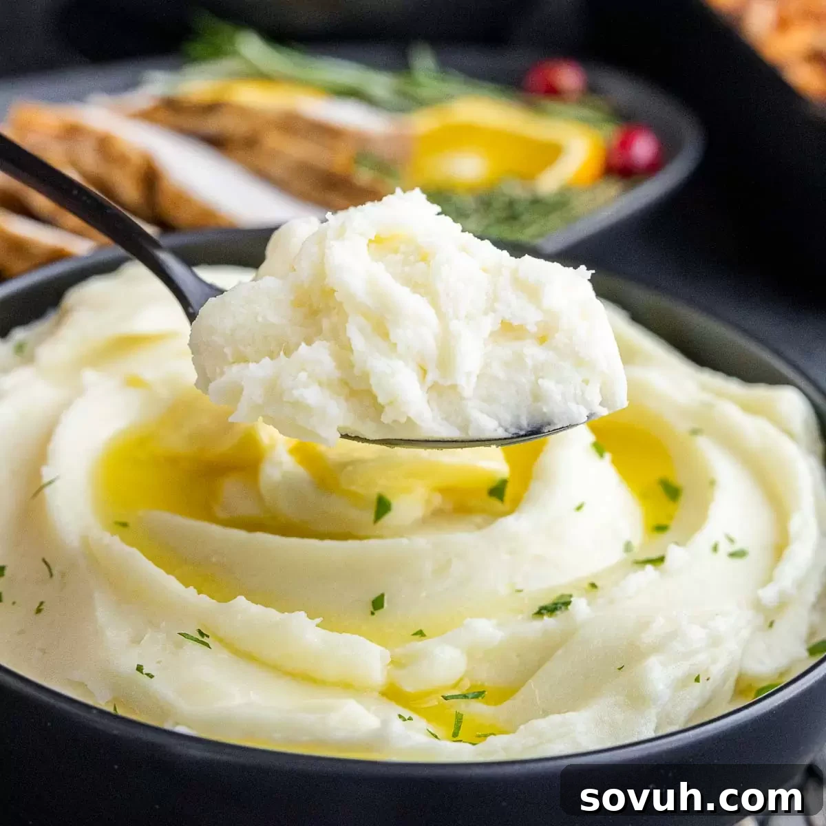 Rich and creamy mashed potatoes served on a spoon, ready to be enjoyed.