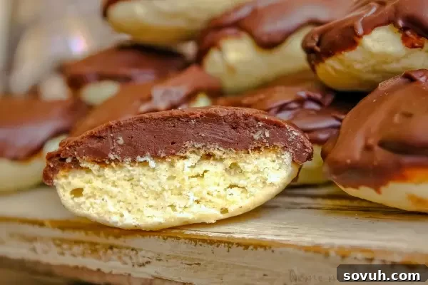 A close-up view of a homemade Berger Cookie, showcasing its distinctive thick layer of fudge frosting and soft cookie base.