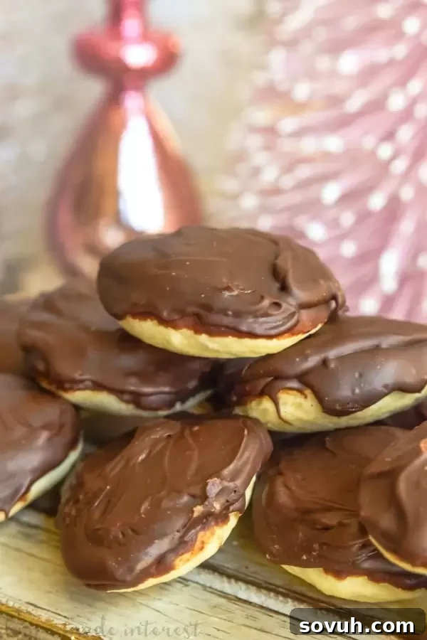 A beautiful vertical shot of a freshly made Berger Cookie, highlighting its impressive thick fudge topping and soft texture.