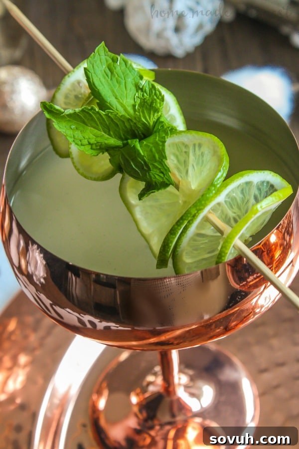 A vibrant vertical shot of a Champagne Moscow Mule garnished with lime and mint, sparkling with celebration.