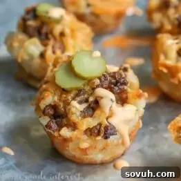 Crispy mini cheeseburger tater tot cups topped with special sauce and mini pickles, perfect for a game day or Super Bowl party appetizer.