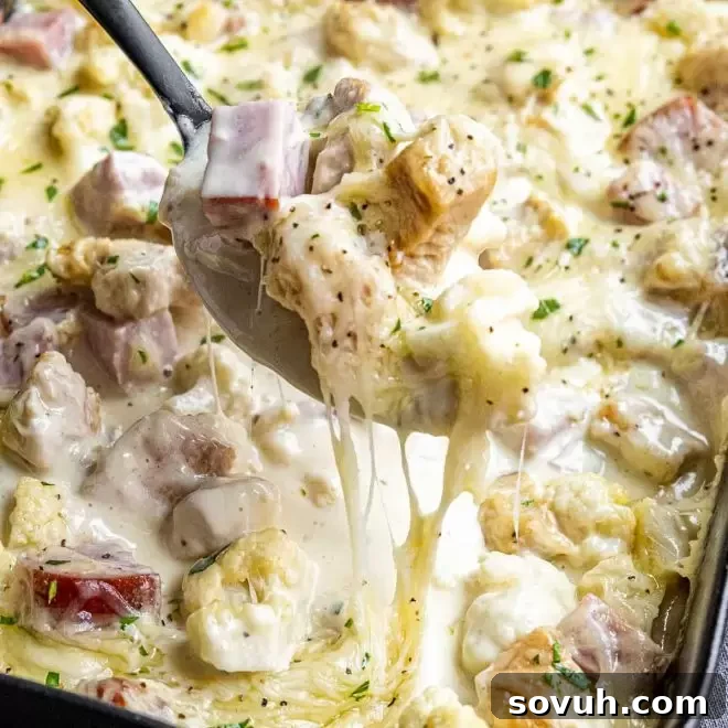 Cheesy Keto Chicken Cordon Bleu Casserole served on a spoon, showing its creamy texture and golden top