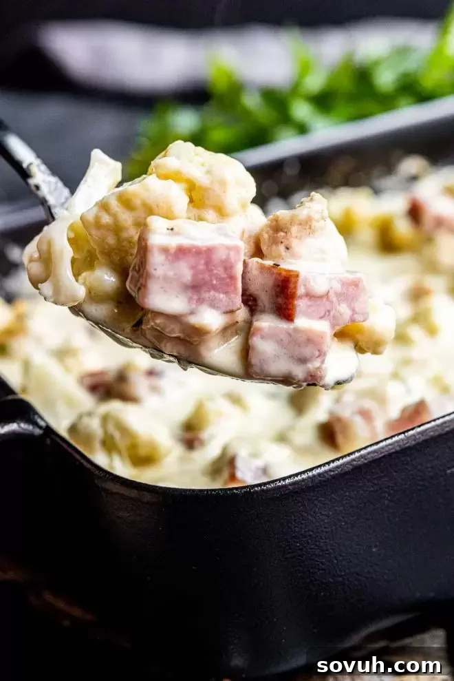 A serving of Keto Chicken Cordon Bleu Casserole scooped into a bowl, showing the melted cheese and hearty ingredients