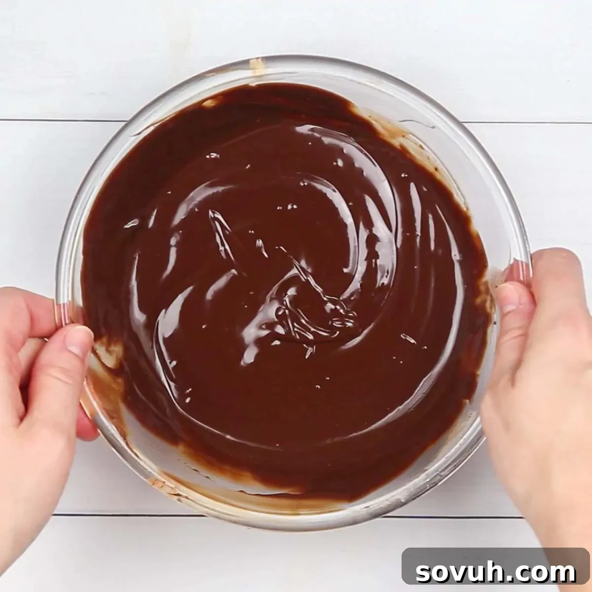 Finely chopped dark chocolate pieces ready in a glass bowl, awaiting the hot heavy cream to transform into a glossy chocolate ganache for the ultimate brownie cake topping.