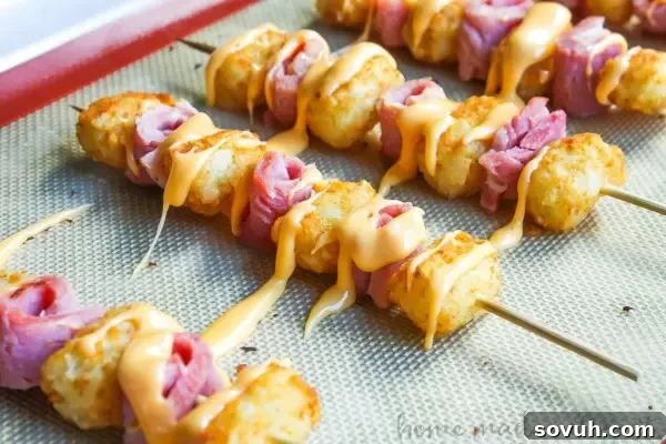 Ham and Cheese Tater Tot Skewers | If you are looking for a simple but totally awesome Game Day appetizer this game day recipe is it. Ham and Cheese Tater Tot Skewers are an easy appetizer recipe with layers of ham and tater tots skewered together and drizzled with creamy american cheese. This is going to be perfect food for your next super bowl party or football party!
