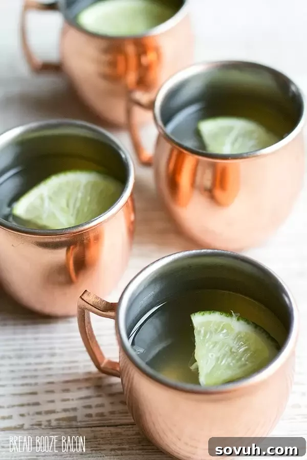 A tray of freshly made Moscow Mule Jello Shots in small cups, ready for chilling.