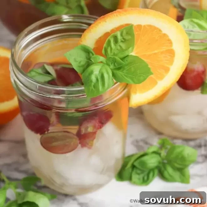 Mason jar filled with sliced grapes and basil leaves