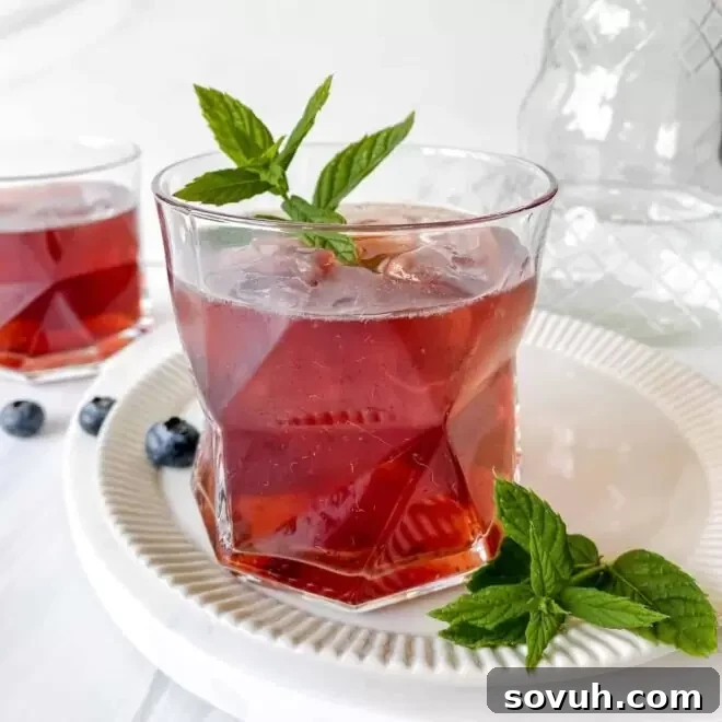 glass filled with blueberry agua fresca and a sprig of mint