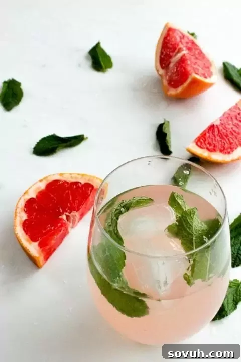 glass of pink grapefruit and mint infused water with ice.