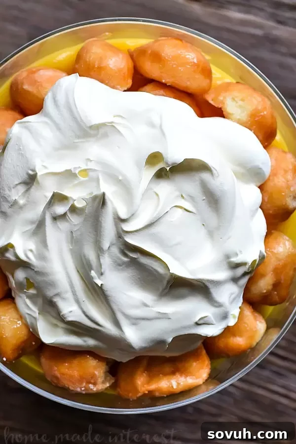 Donut Trifle | This decadent dessert recipe uses Krispy Kreme doughnuts to make an easy trifle recipe. Layers of whipped cream, vanilla pudding and donut holes makes an easy donut trifle recipe that everyone is going to love. Trifle is an easy dessert recipe for the holidays and it would make a great potluck dessert recipe for summer picnics.