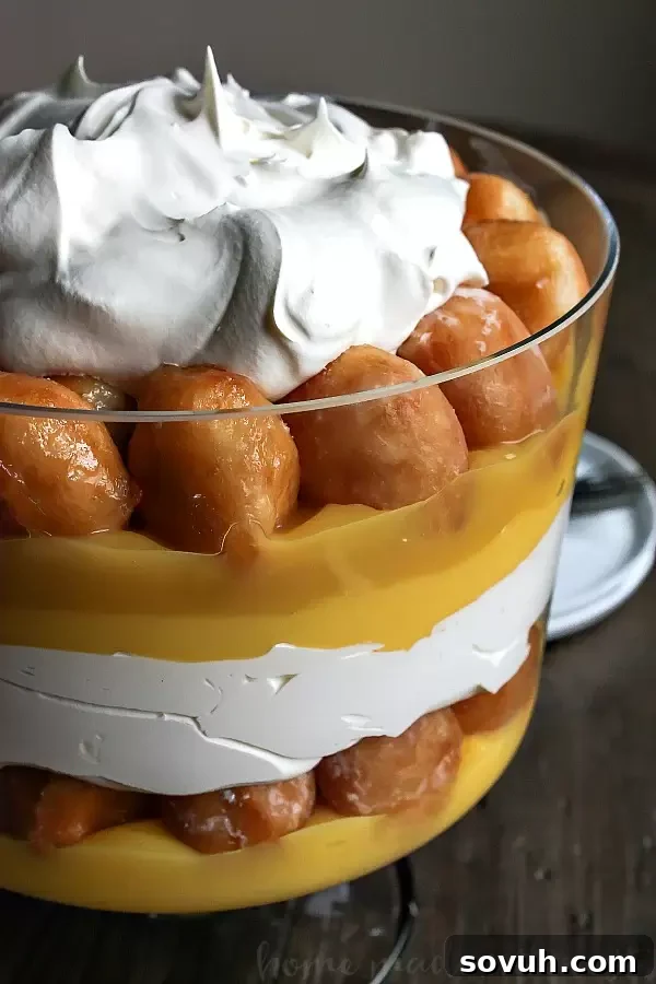 Donut Trifle | This decadent dessert recipe uses Krispy Kreme doughnuts to make an easy trifle recipe. Layers of whipped cream, vanilla pudding and donut holes makes an easy donut trifle recipe that everyone is going to love. Trifle is an easy dessert recipe for the holidays and it would make a great potluck dessert recipe for summer picnics.