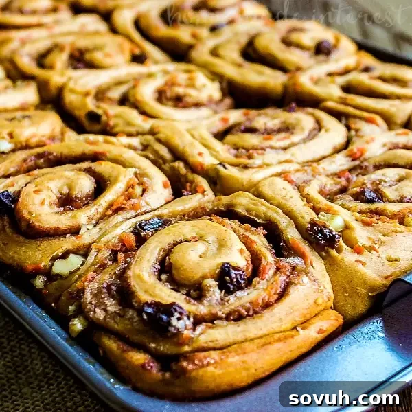 Fluffy Carrot Cake Cinnamon Rolls topped with cream cheese frosting, a perfect Easter brunch treat.