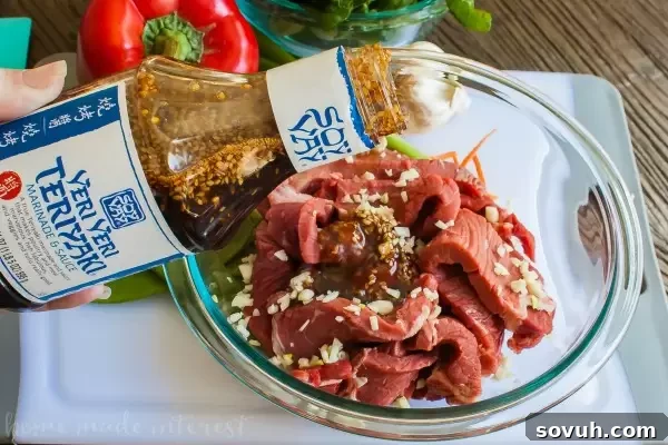 Preparing Sheet Pan Beef Teriyaki, pouring delicious teriyaki sauce over thinly sliced beef and vibrant Asian vegetables.