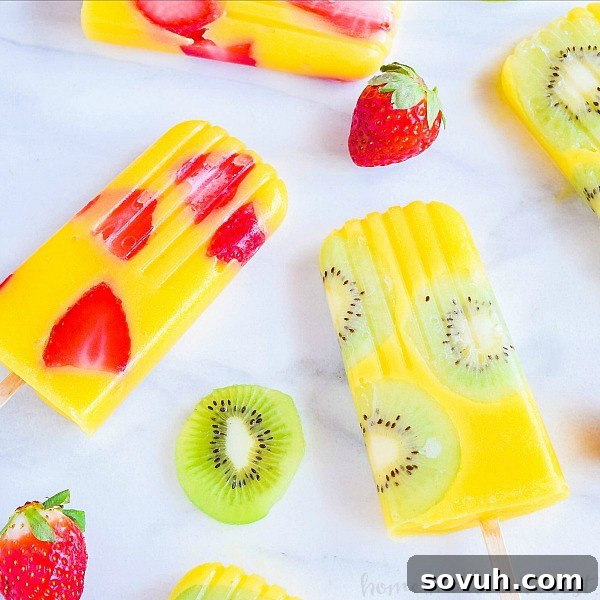 Mango popsicles with strawberry slices and kiwi slices