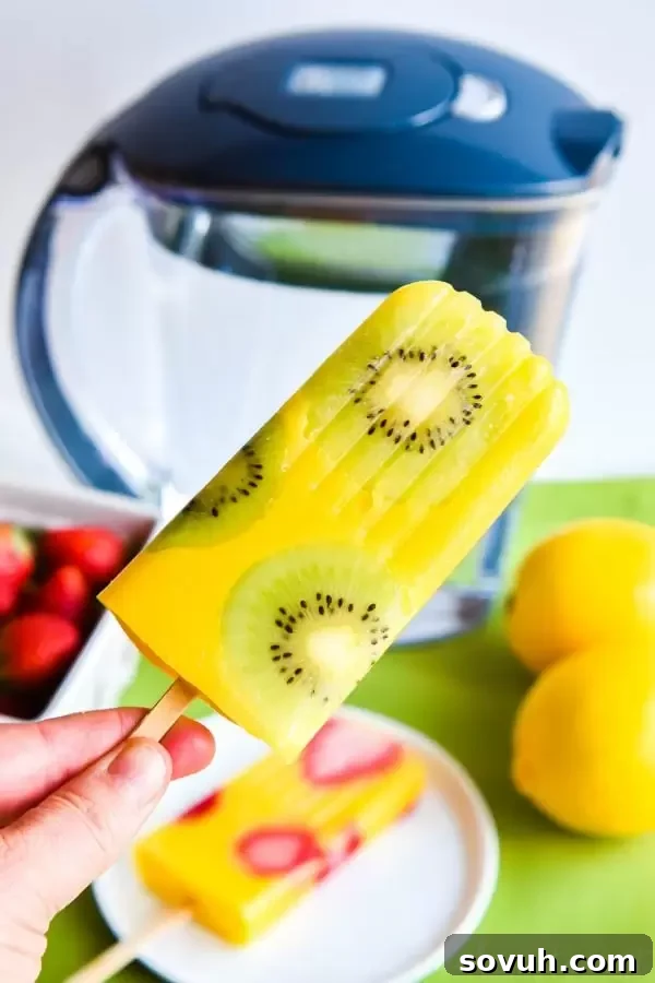 A kiwi mango popsicle on a stick