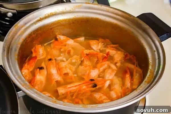 Making the rich shrimp broth, a key step for the intensely flavorful filling of Portuguese Shrimp Turnovers (Rissóis de Camarão). This traditional technique ensures maximum shrimp flavor for your party appetizers.