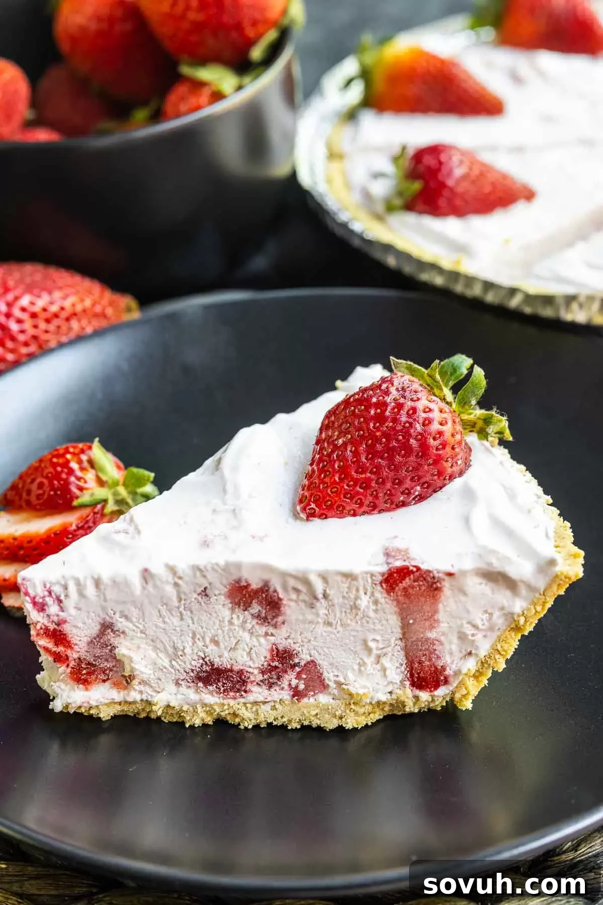 Slice of Frozen Strawberry Pie on a white plate, highlighting the creamy texture and crust
