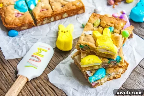 Colorful Easter Blondies 3 Close-up of golden blondie bars studded with vibrant Easter candy, including melted Peeps, chocolate eggs, and other treats. A fantastic way to enjoy a variety of Easter sweets.