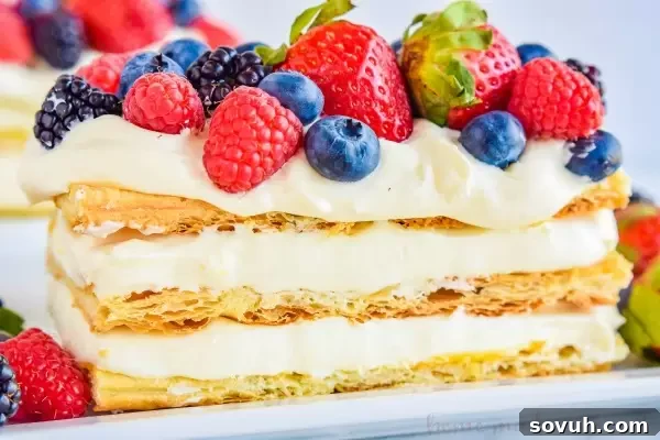 Close-up view of the layers in a Lemon Berry Napoleon, showing creamy lemon mousse and crisp puff pastry.