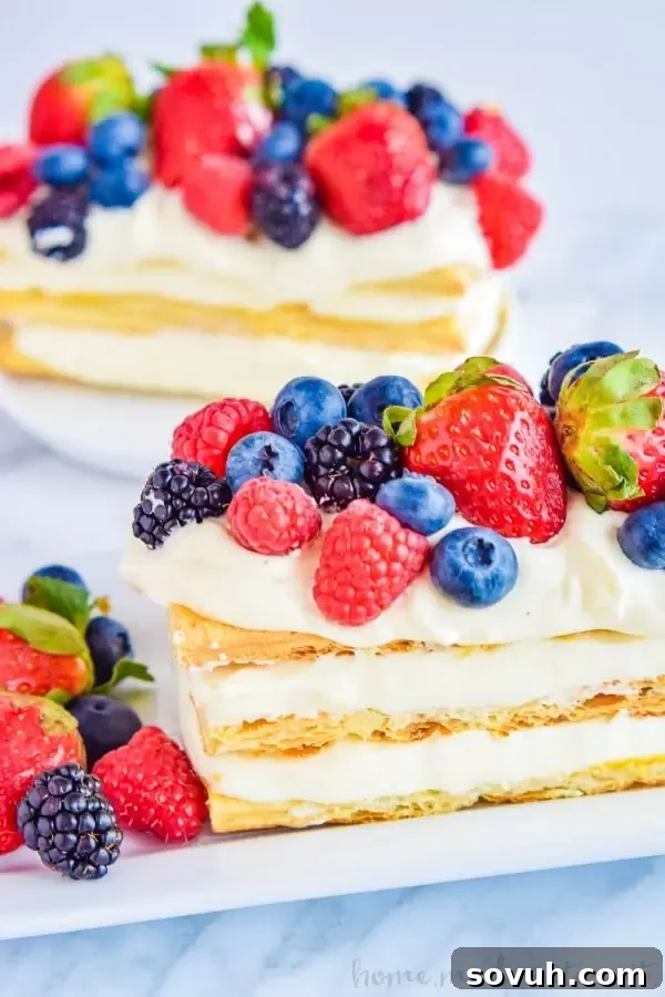Vertical shot of a Lemon Berry Napoleon, highlighting its stacked layers and vibrant fruit topping.