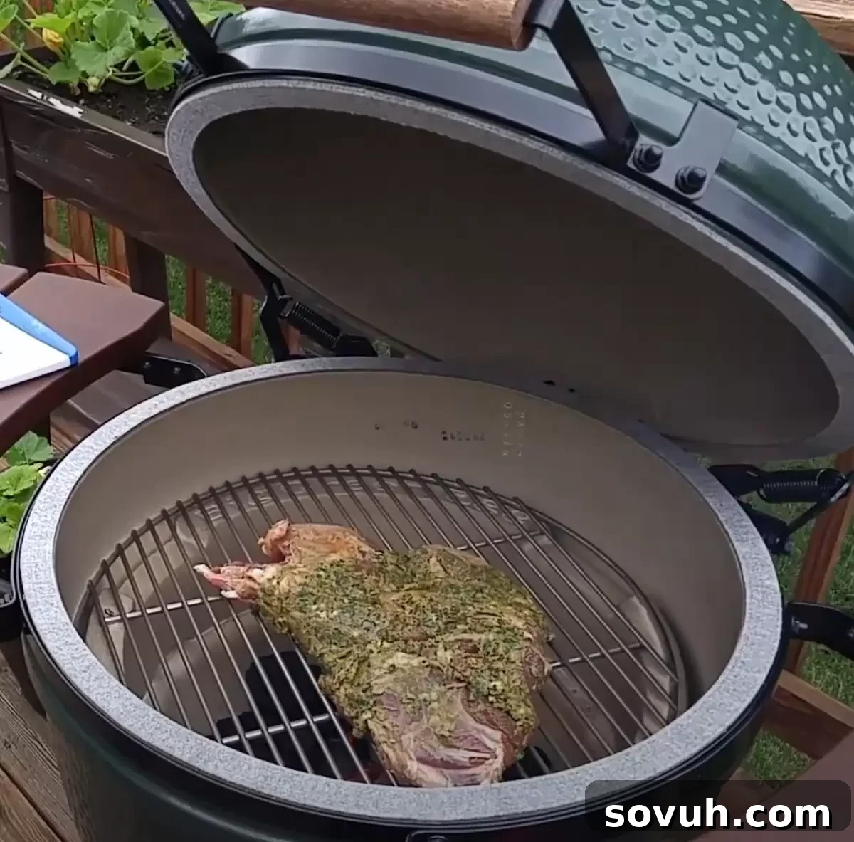 Herb Crusted Leg of Lamb on the grill covered in herbed marinade