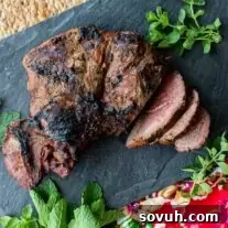 sliced grilled leg of lamb on a black cutting board