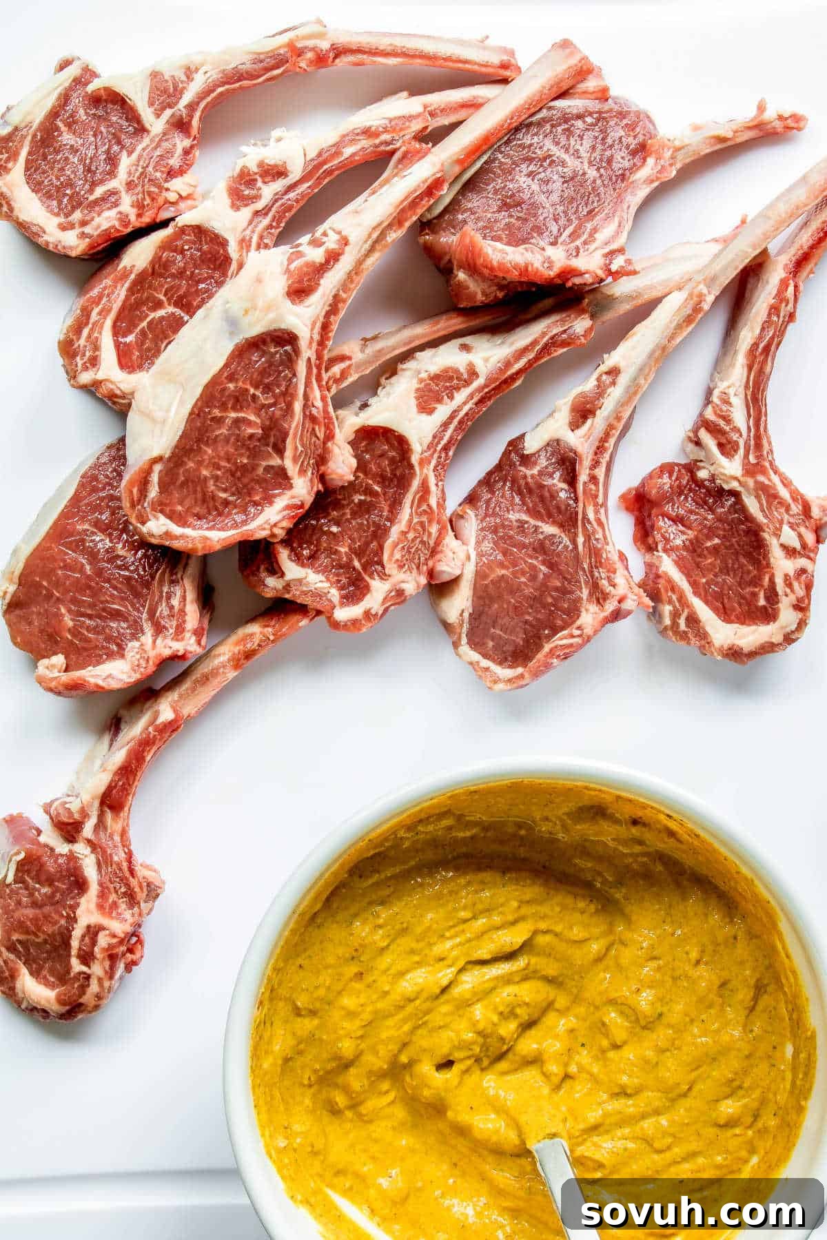 Preparing the Tandoori marinade ingredients in a bowl with fresh lamb chops nearby, ready for marination.