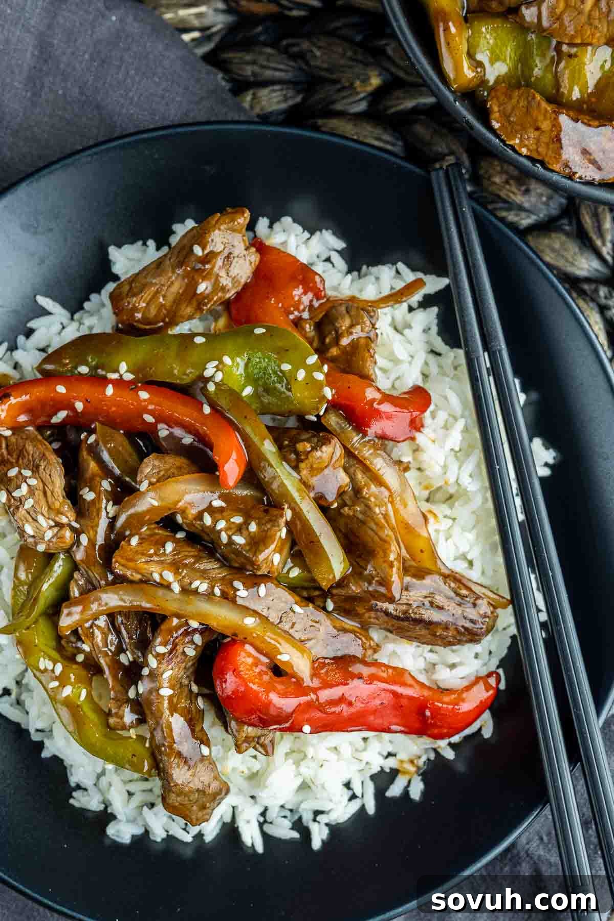 A close-up of Easy Pepper Steak on a black plate, showcasing the tender beef and vibrant bell peppers.