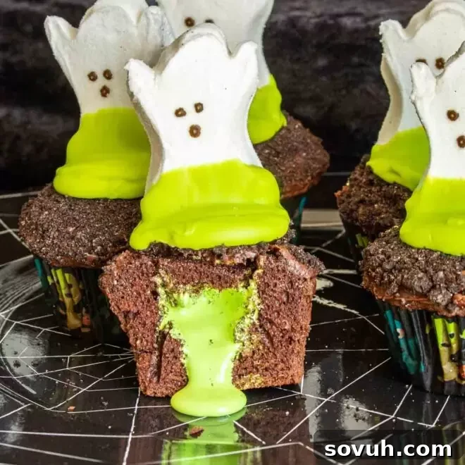 Delicious ghost goo Halloween cupcakes oozing green cream, perfect for a spooky party