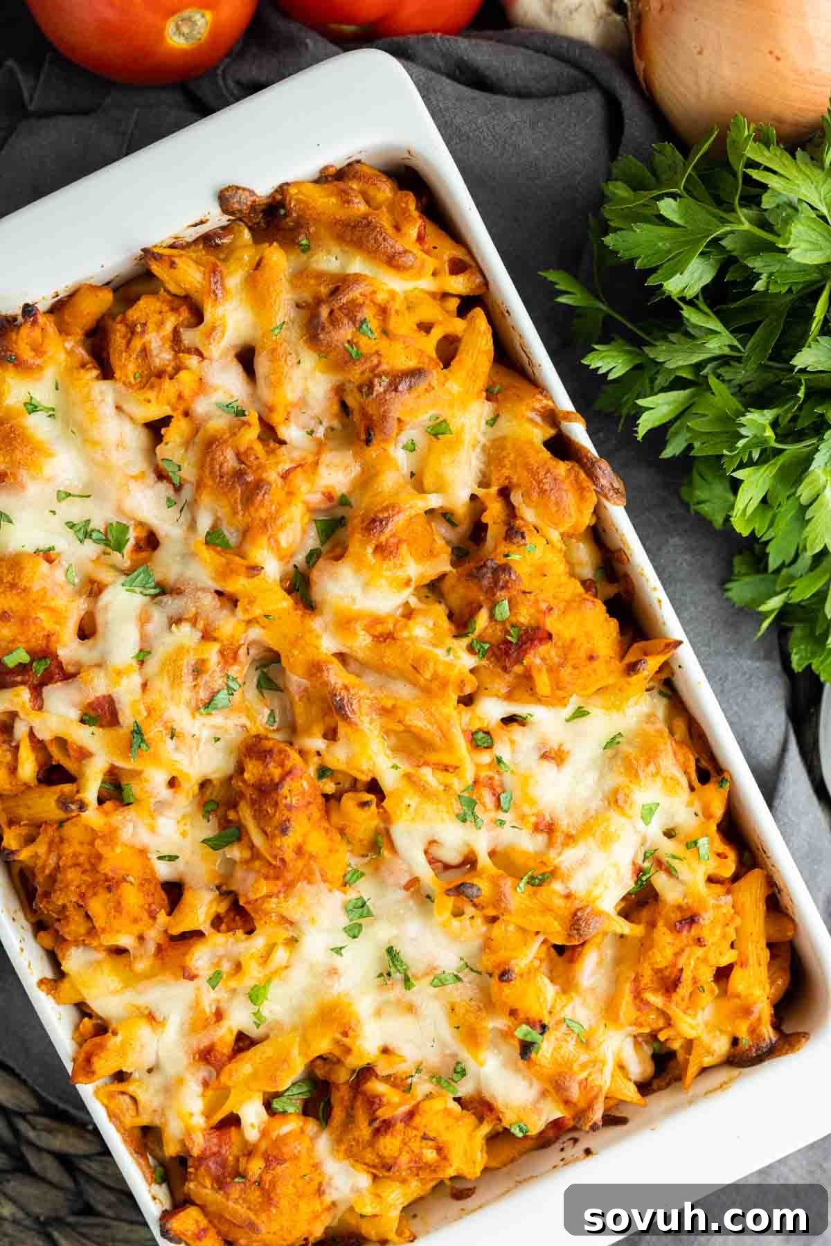 Cheesy Chicken Parm Bake 6 Baked Chicken Parmesan Casserole, garnished with fresh parsley, in a serving dish.