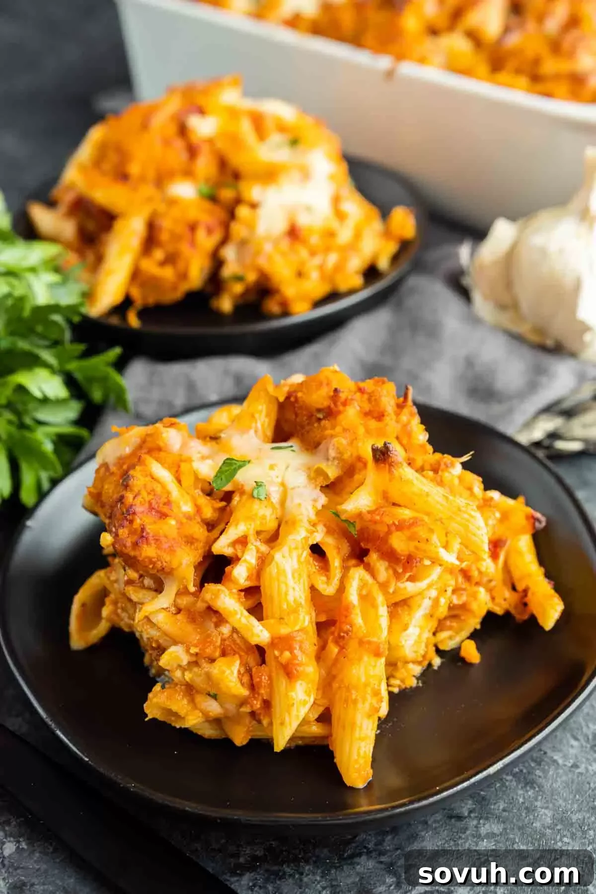 Cheesy Chicken Parm Bake 7 A serving of Chicken Parmesan Casserole on a black plate, ready to be enjoyed.