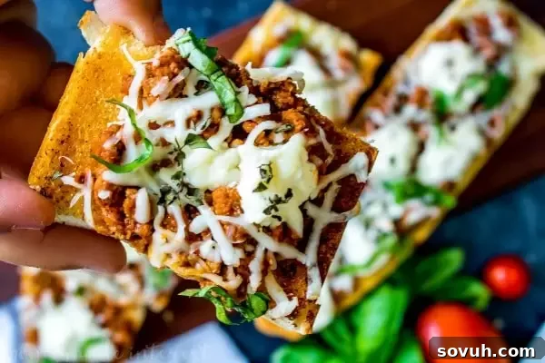 Lasagna French Bread Melts 3 hand holding one slice of lasagna french bread pizza