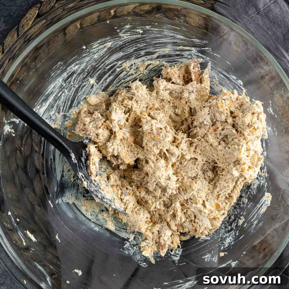 A glass bowl filled with a mixture Crab Pretzel