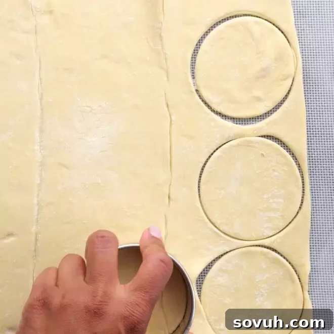 Puff pastry being cut into rounds with a cookie cutter for Halloween Baked Cheese.
