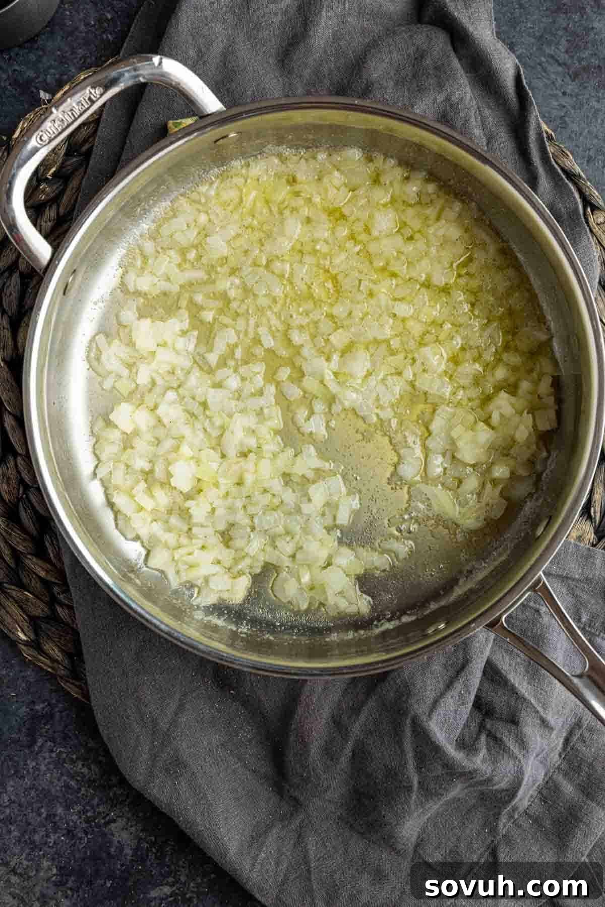 Diced onions sautéing in a skillet with melted butter, turning translucent and tender.