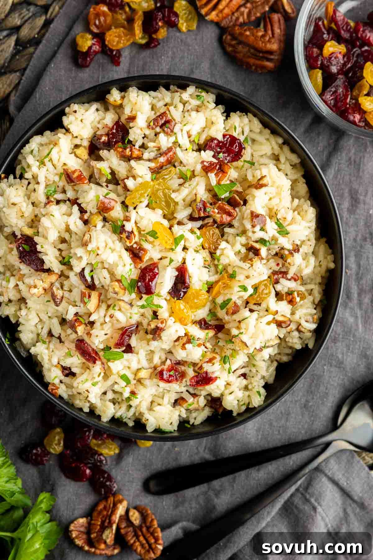 A freshly cooked Pecan Rice Pilaf, fluffed with a fork and ready for the final touches, in a large skillet.