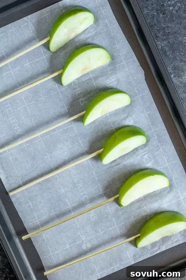 Slices of crisp apples ready on kabob sticks for dipping in chocolate