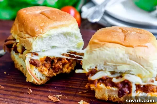 Two Lasagna Sliders being pulled apart, showing the gooey melted cheese and rich meat sauce.