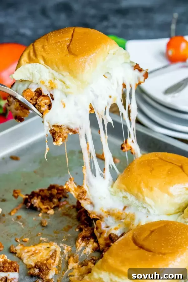 A Lasagna Slider being lifted from a baking sheet, showcasing the layers of meat, cheese, and ricotta.