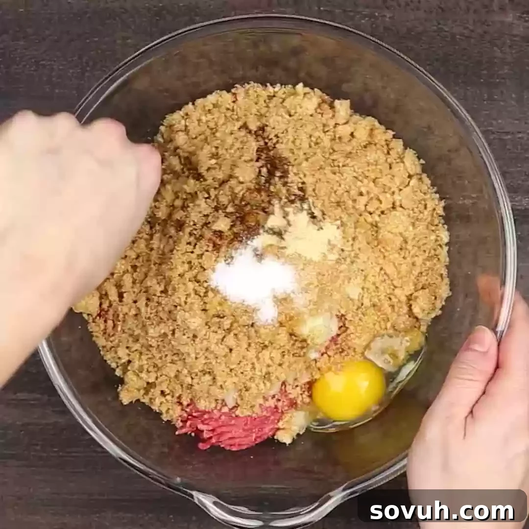 A person mixing keto meatloaf ingredients in a bowl.