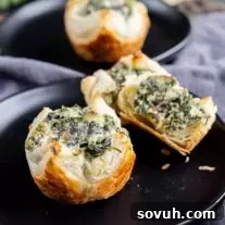 Spinach Puffs bites on a black plate.