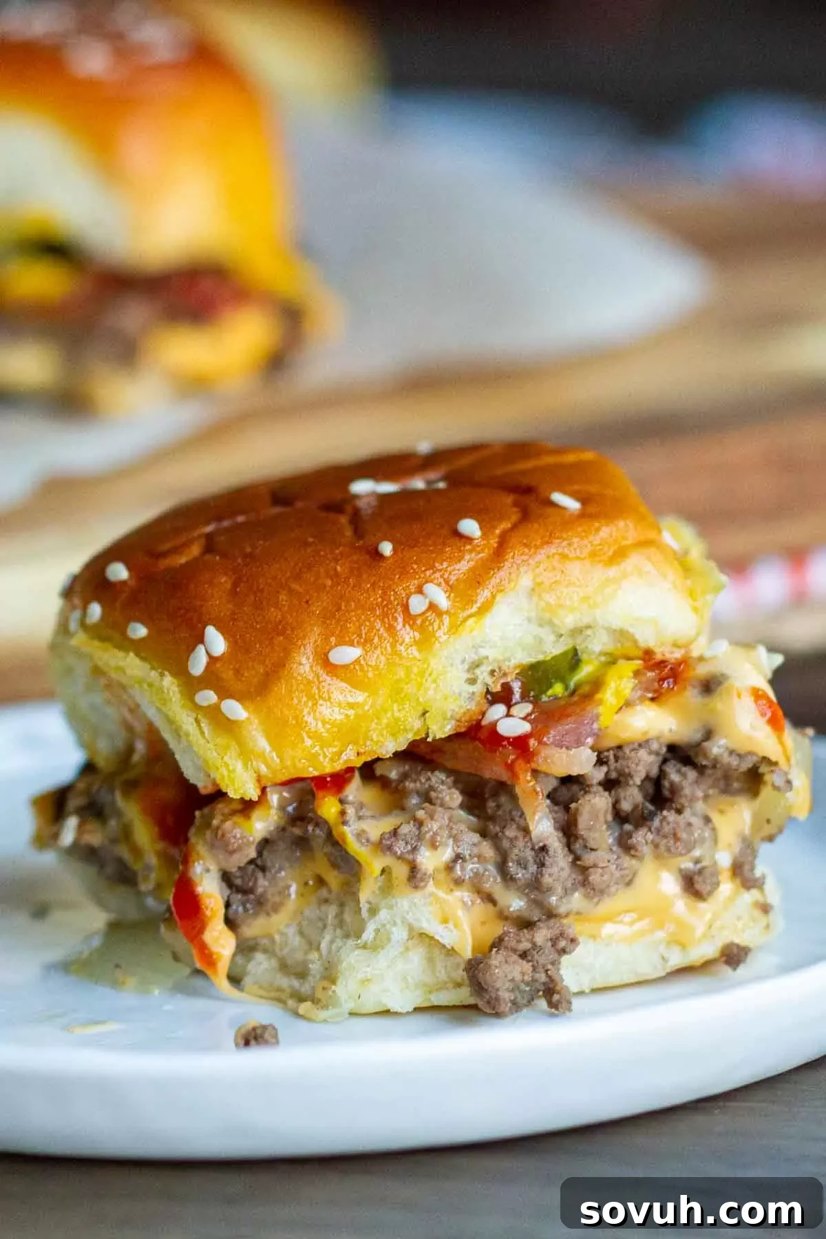 A pristine white plate showcasing an arrangement of tempting Bacon Cheeseburger Sliders