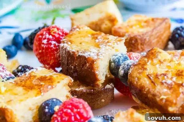 closeup of lemon poundcake french toast skewers with fresh berries and powdered sugar, highlighting the texture and colors