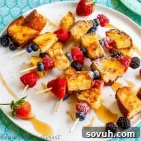 Lemon poundcake french toast skewers on a white plate with powdered sugar