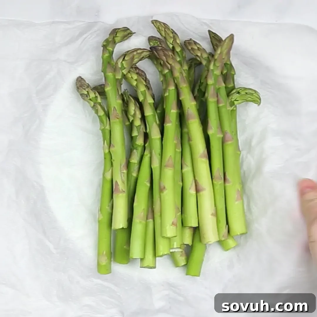 A bunch of steamed asparagus on a white paper to make Asparagus Casserole