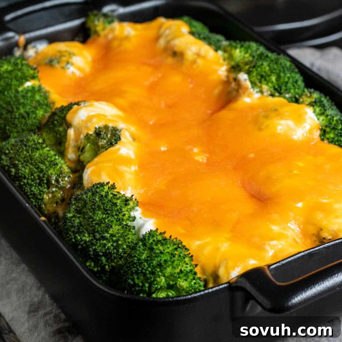 Broccoli Cheese Casserole in black casserole dish, steaming hot and ready to serve