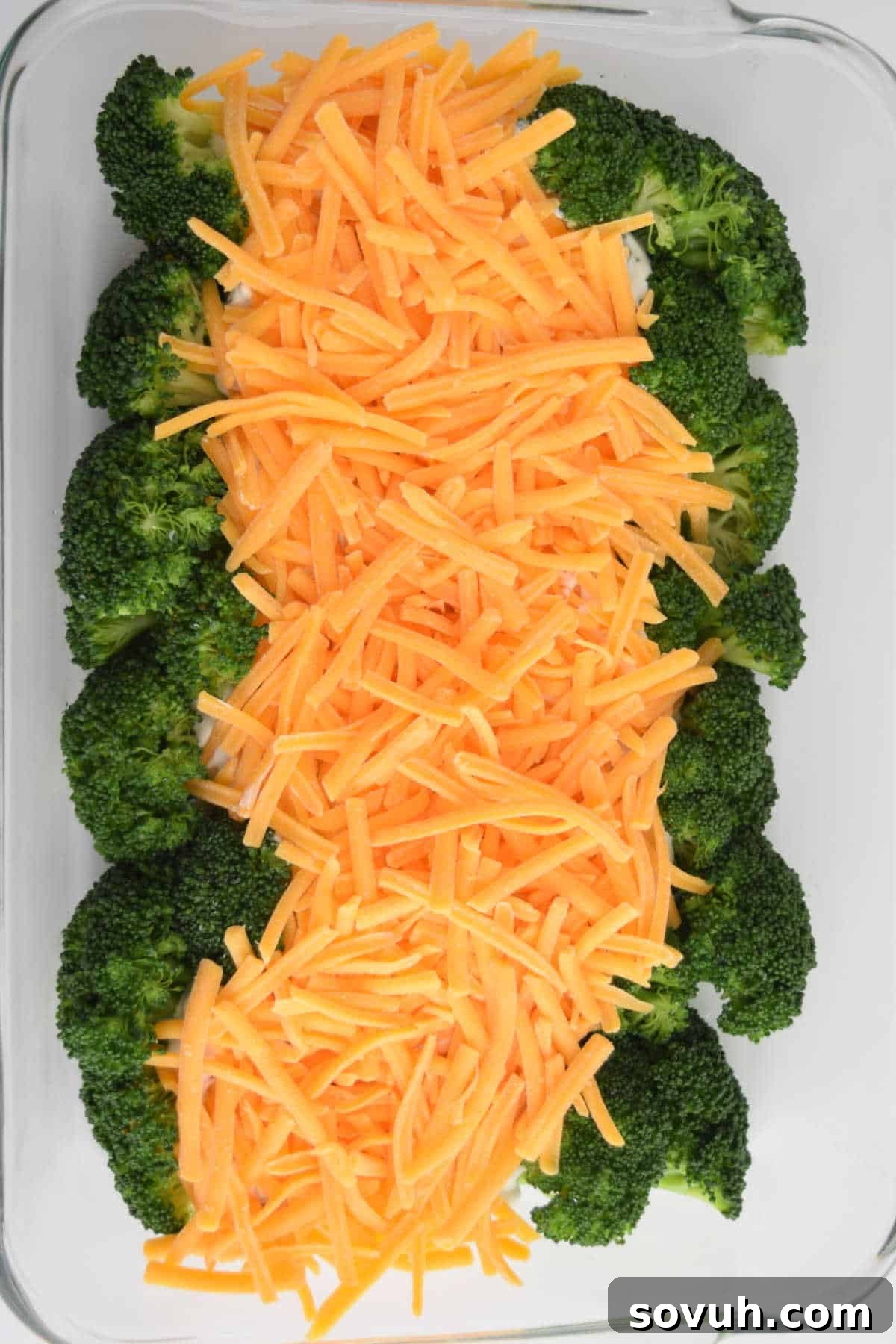 Broccoli Cheese Casserole generously topped with shredded cheddar cheese